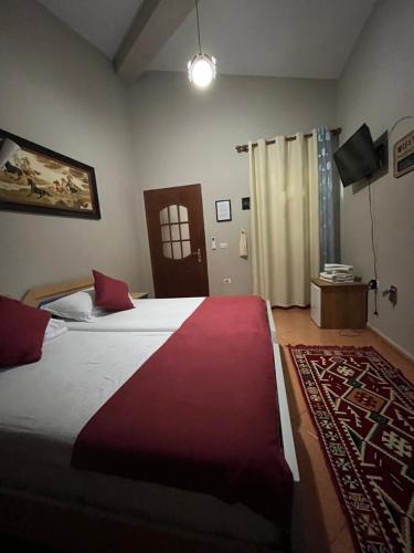 克鲁亚ROOMS EMILIANO Castle of Kruja的一间卧室配有一张带红色毯子的大床