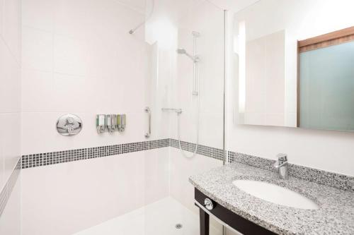 谢菲尔德希尔顿谢菲尔德汉普顿酒店的白色的浴室设有水槽和镜子