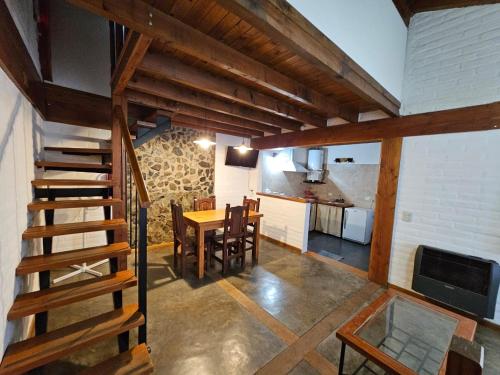 埃博森Punto Sur Cabañas的房屋内的厨房和用餐室,设有楼梯