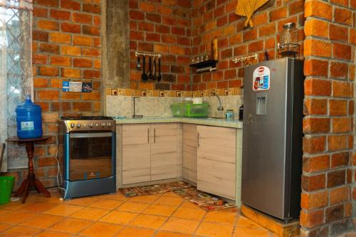 卡塔马约Casa Ensueño的厨房设有砖墙和冰箱。