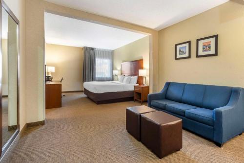 查尔斯顿Comfort Inn & Suites Airport Convention Center的酒店客房配有蓝色的沙发和床。