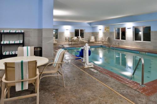 堪萨斯城堪萨斯城希尔顿恒庭酒店（靠近欢乐世界）的游泳池旁设有桌椅