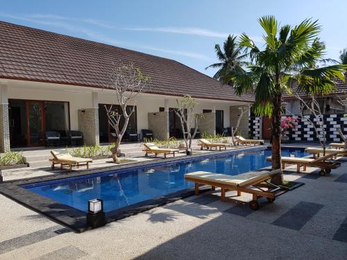 吉利特拉旺安松树别墅酒店的一个带躺椅的游泳池和一个度假村