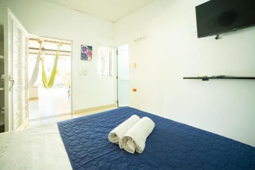 托卢Hostal del Mar - Tolu的一间卧室配有蓝色的床和毛巾