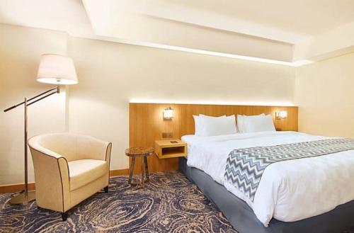 三宝垄三宝垄路易斯基安纳酒店的配有一张床和一把椅子的酒店客房