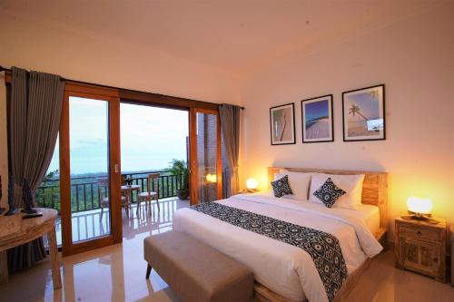 BatununggulMere Sea View Resort & Spa的一间带大床的卧室和一个阳台