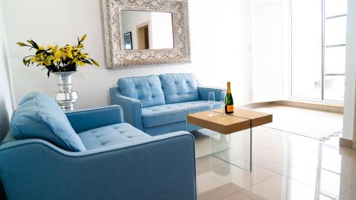 蓬塔卡纳Boutique Hotel Las Flores Punta Cana的客厅配有蓝色的椅子、桌子和镜子