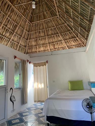 El Paredón Buena VistaCuarto Palma的一间卧室设有一张床和稻草屋顶