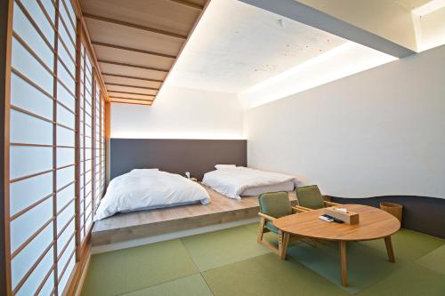 京都Forest Gardianホテル 京都御所西的卧室配有一张床和一张桌子及椅子