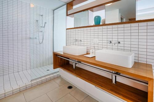 耐莉湾Best at Bright Point Absolute Waterfront Apartment的一间带两个盥洗盆和淋浴的浴室