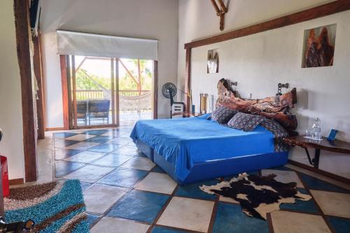 金巴亚Finca Turística La Casa que Canta的卧室配有蓝色的床,铺有瓷砖地板。