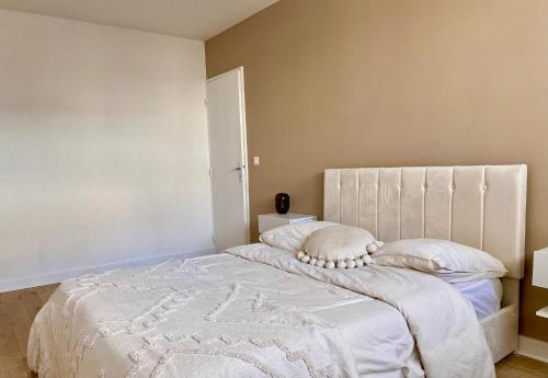 巴黎Suite Bella vista : piscine & vue panoramique的卧室配有一张带白色床单和枕头的大床。