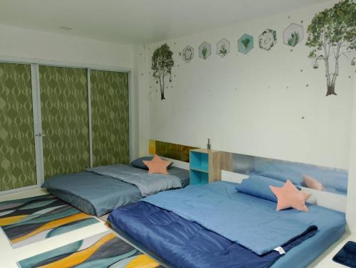 那空拍侬府พญาเกสท์เฮ้าส์的卧室设有两张床铺和绿色的墙壁