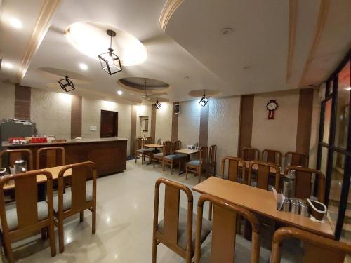 奈尼塔尔Goroomgo Moon Nainital Near Naini Lake - Parking & Lift Facilities -Hygiene and Spacious Room - Best Seller的餐厅内带桌椅的用餐室