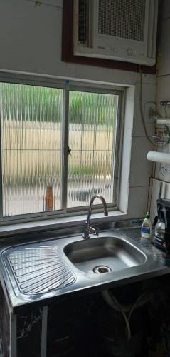 里约热内卢kitnet próximo a praia的带窗户的厨房内的盥洗盆
