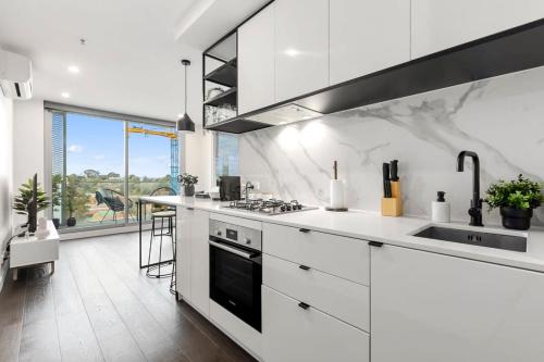 墨尔本Grandeur Apartment的白色的厨房配有炉灶和水槽