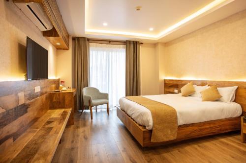加德满都HOTEL BHRIKUTI TARA的配有一张床和一把椅子的酒店客房