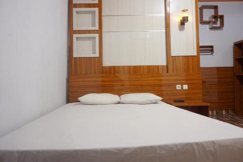 肯达利OYO 93770 Pondom Danu 77的一张白色的床,上面有两个枕头