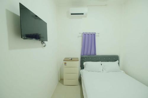 Laleng-balandaeOYO 93756 Qq Kost的一间卧室配有一张床和一台平面电视