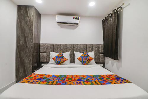 新德里FabExpress Super 8 Residency的一间卧室配有一张带彩色毯子的床