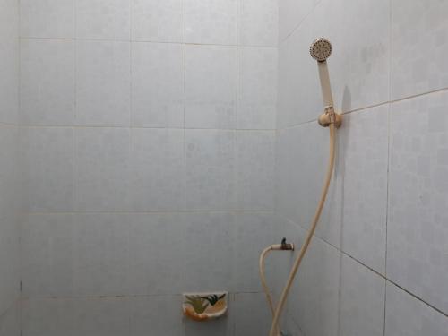 名古屋SPOT ON 93776 Intan Homestay的白色瓷砖浴室内的淋浴头