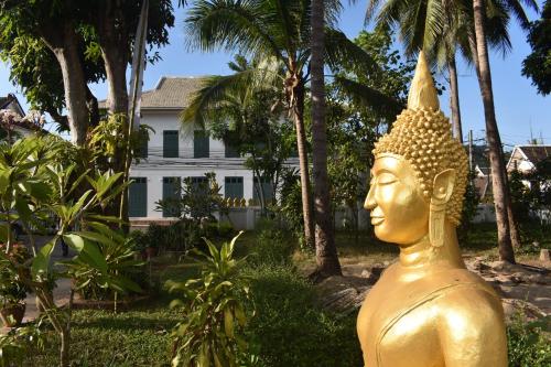 琅勃拉邦PHA NYA RESIDENCE的一座房子前面的金雕