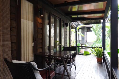 清迈Baan Saen Fang Chiang Mai - SHA Plus的门廊上配有桌椅的天井