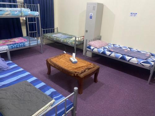 阿布扎比Dream valley hostel的客房设有三张双层床和一张桌子。