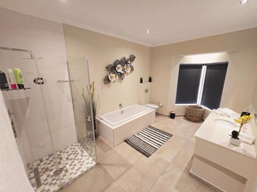 BedfordviewVilla Reis - The Villa of Kings的带浴缸、淋浴和盥洗盆的浴室