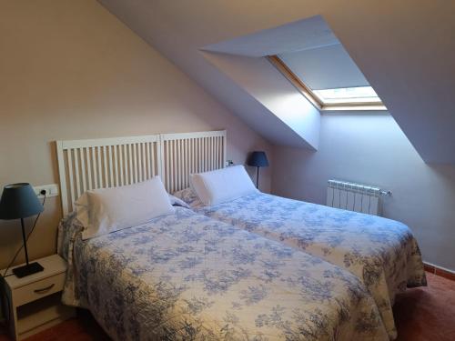 康达Apartamentos Astilleros的一间卧室配有一张带蓝白色毯子的床