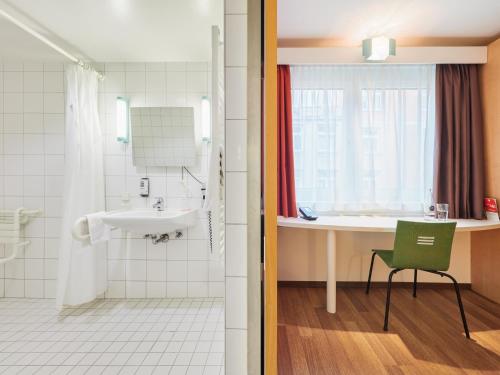 斯图加特斯图加特市中心宜必思酒店的一间带水槽、淋浴和绿色椅子的浴室