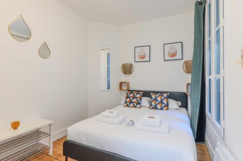 巴黎Cozy Parisian Retreat in the Heart of the City的一间卧室配有一张带白色床单的床和一张书桌。