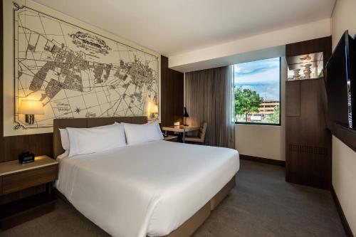 波哥大波哥大机场万怡酒店的酒店客房设有一张大床,墙上挂有地图