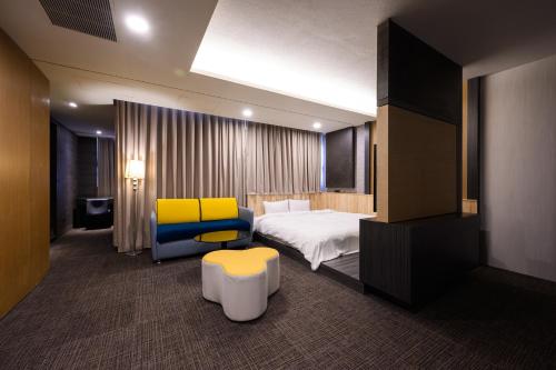 中和集瑷饭店的酒店客房,配有床和黄色椅子