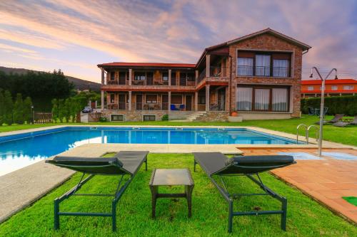 波伊奥阿马奎亚酒店的一座房子前面设有游泳池和两把椅子