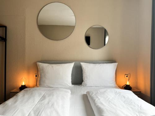慕尼黑辛德林格尔托酒店的一间卧室配有两面镜子和一张带白色枕头的床