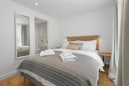 伊斯特布恩Chic Urban Retreat: Modern Apartment in Eastbourne的一间卧室配有一张床,上面有两条毛巾