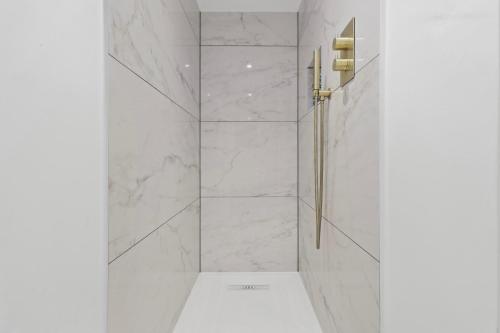 伊斯特布恩Chic Urban Retreat: Modern Apartment in Eastbourne的白色的浴室设有大理石墙壁和淋浴。