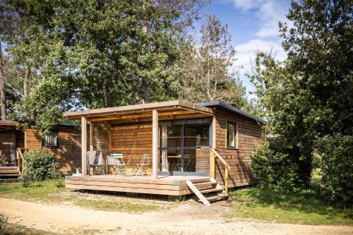 艾克塞恩维克斯Camping La Pinède的小木屋设有门廊和甲板