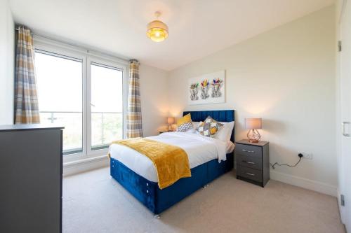 克劳利Modern 2 Bed Apartment in Crawley - Sleeps 5的一间卧室设有蓝色的床和窗户。