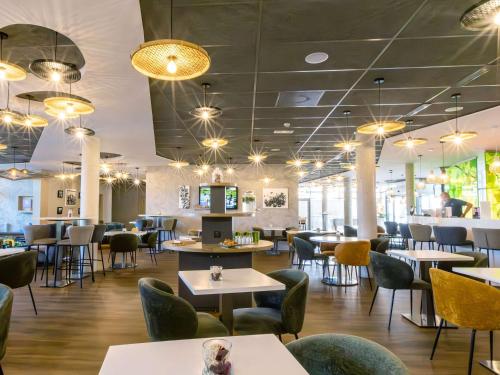 特鲁瓦ibis Styles Troyes Centre的一间带桌椅和灯光的餐厅