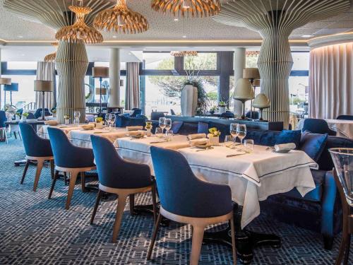 沙特拉永普拉日La Grande Terrasse Hotel&Spa La Rochelle MGallery Hotel Collection的用餐室配有桌椅和吊灯。
