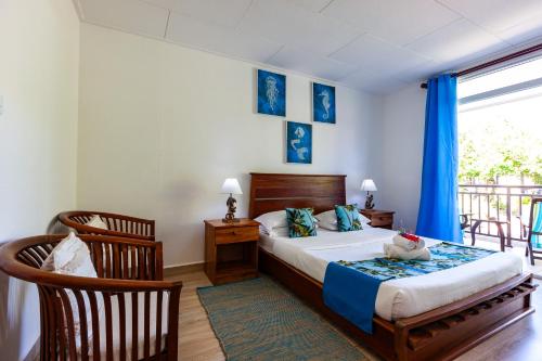 拉迪格岛马斯顿度假屋的一间卧室配有床,阳台配有蓝色窗帘