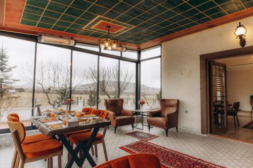 内夫谢希尔Cappadocia Villa Comfort的客厅配有桌椅和窗户。