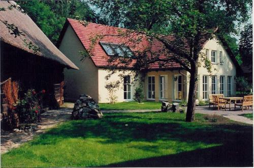 勒赫德Fewo Fischotter的白色的房子,有红色的屋顶和院子