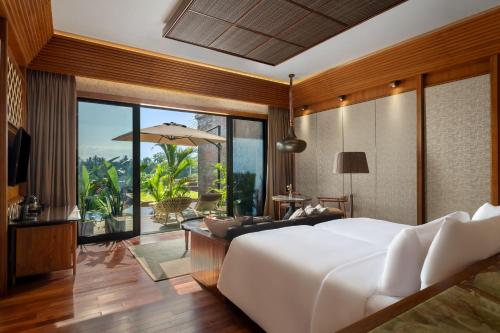 日惹Garrya Bianti Yogyakarta的卧室设有一张白色大床和一个庭院。