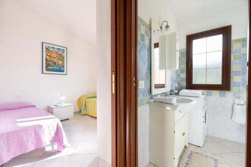 圣特奥多罗Angel Village的白色的浴室设有水槽和一张床