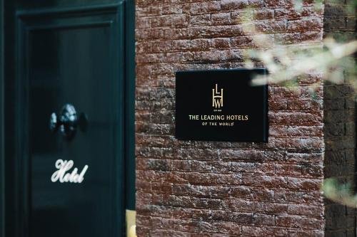 阿姆斯特丹The Dylan Amsterdam - The Leading Hotels of the World的砖墙边的标志
