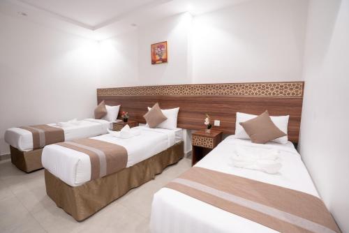 麦加فندق سيف بلص من سما的配有白色墙壁的酒店客房内的两张床