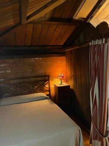 RíosecoCasa rural en Redes的一间卧室配有一张床和一张桌子上的台灯
